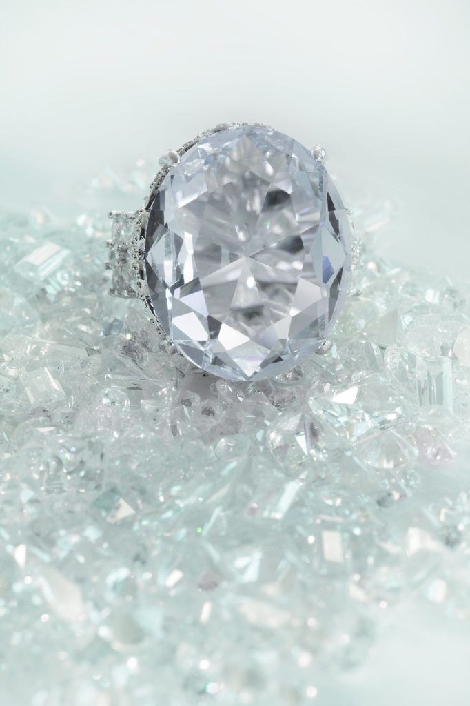 Beautiful large diamond engagement wedding ring sitting on diamonds scattered background